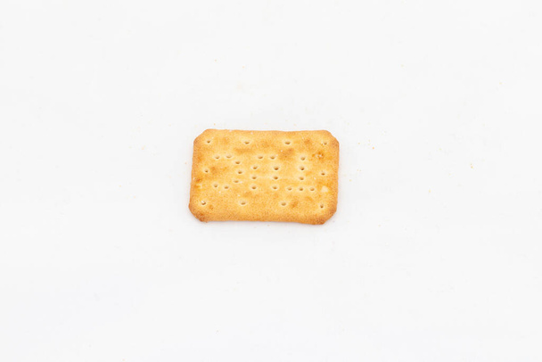 Ein einzelnes Stück salziger Cracker in rechteckiger Form auf weißem isolierten Hintergrund mit Kopierraum. - Foto, Bild