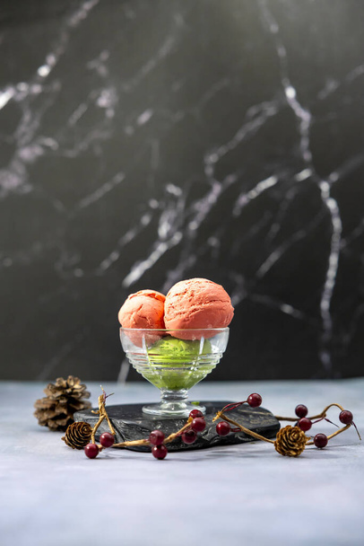 Aardbei en matcha groene thee ijs gelato met rode bessen en dennenappel decoratie voor de winter en kerst dessert - Foto, afbeelding