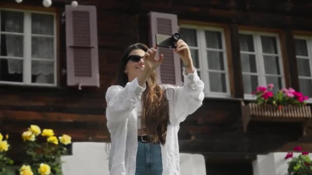 We were shooting on the phone. The girl is filming on a cell phone with a lens. The detachable lens on the phone. Traveling. A young brunette girl traveling and taking photos on the phone. High - Footage, Video