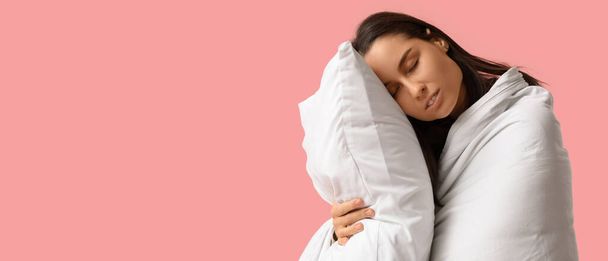 Sleepy young woman with blanket and pillow on pink background with space for text - Photo, Image