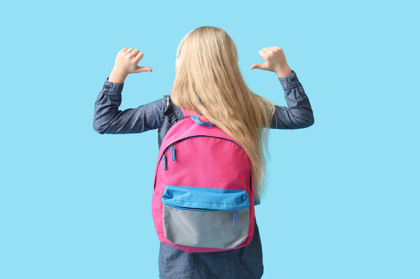 Roztomilé školačka s batohem na modrém pozadí - Fotografie, Obrázek