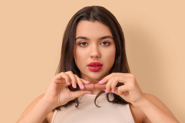 Beautiful young woman with stylish lipstick on beige background - Photo, Image