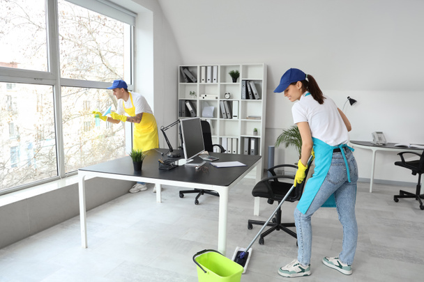 Genç hademeler ofiste temizlik yapıyor. - Fotoğraf, Görsel