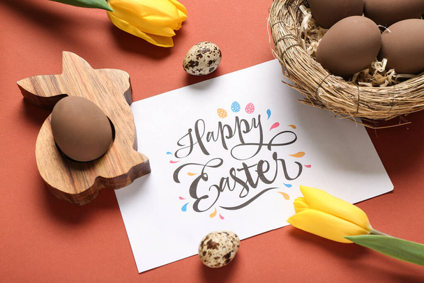Pozdrav s textem HAPPY EASTER, malované vejce a tulipány na červeném pozadí - Fotografie, Obrázek
