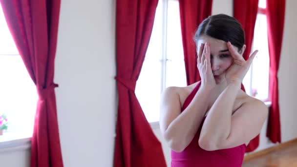 Ελκυστική κοπέλα κάνει αστείες γκριμάτσες - εσωτερικά - κόκκινη κουρτίνα - Πλάνα, βίντεο