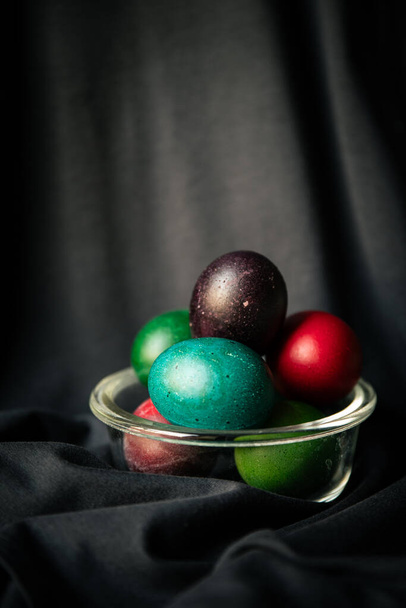 Easter colorful eggs on a dark fabric. - Photo, Image