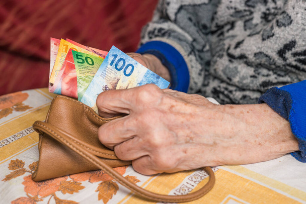 Ένας συνταξιούχος στην Ελβετία μετράει χρήματα, ελβετικά φράγκα - προβλήματα των ηλικιωμένων, οικονομική έννοια - Φωτογραφία, εικόνα