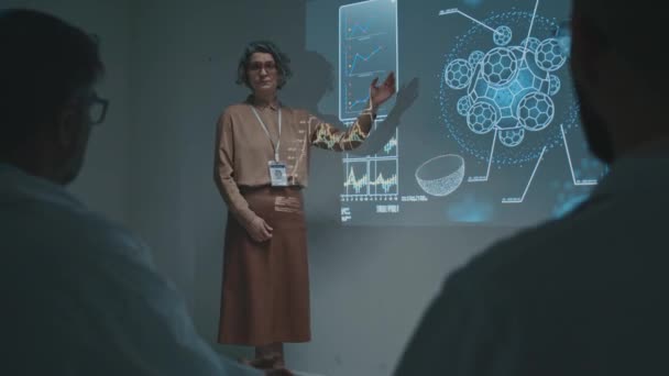 Full shot of Caucasian female research scientist demonstrating slide on projector screen, talking about innovative discovery of new therapy at medical conference, and delighted audience clapping - Footage, Video