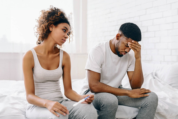 La giovane coppia afroamericana affronta la delusione con un risultato negativo del test di gravidanza in un ambiente domestico - Foto, immagini