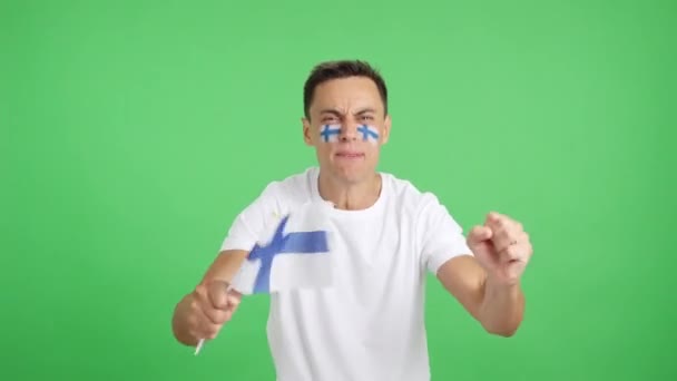 Video en estudio con el croma de un hombre animando apasionadamente a Finlandia gritando y ondeando una bandera nacional - Metraje, vídeo