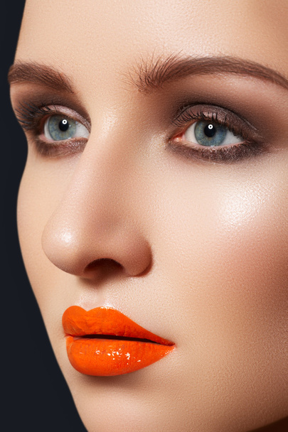 Cute woman model with bright fashion make-up. Sexy lip gloss make-up - 写真・画像