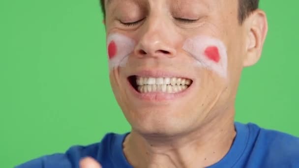 Close-up-Video im Studio mit dem Chroma eines sehr nervösen Mannes mit einer japanischen Flagge im Gesicht, der die japanische Mannschaft während eines schwierigen Spiels unterstützt, das am Ende verloren geht - Filmmaterial, Video