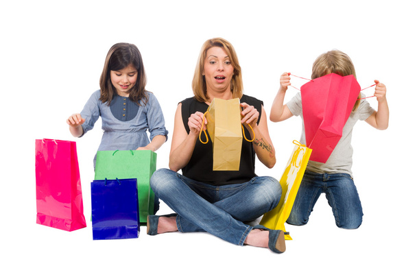 Mãe e filhas verificando os sacos de compras
 - Foto, Imagem