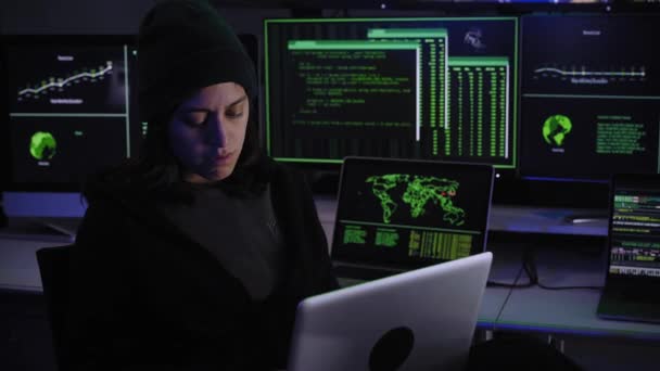 Aufgeregte Frau mit Laptop. Kriminelle Hackerinnen feiern den Erfolg eines Cyberangriffs in dunkler Atmosphäre mit Systemcodes im Hintergrund der Bildschirme. Menschen stehlen vertrauliche Daten. - Filmmaterial, Video