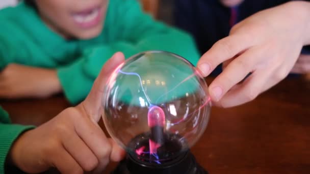 Kleine jongens studeren plasmabal met bliksem aan tafel - Video