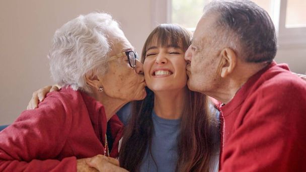 Felices abuelos besando a su nieta mientras ella los visita - Foto, Imagen