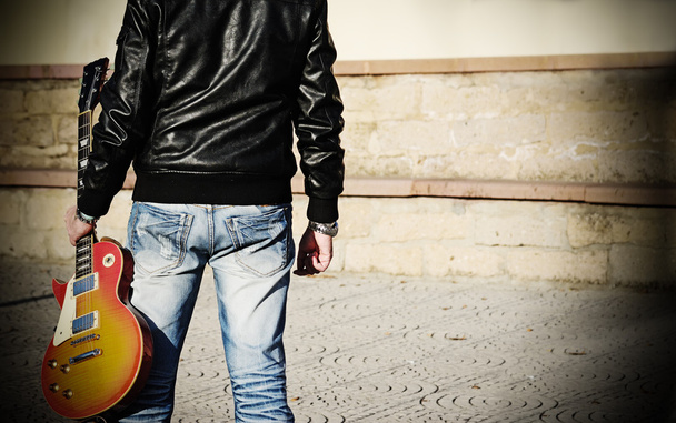 Hombre sosteniendo una guitarra
  - Foto, Imagen