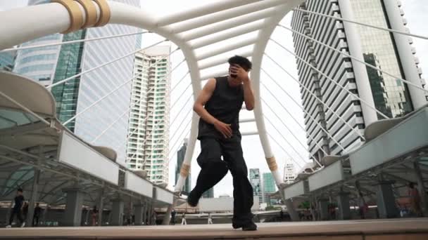 Low angle camera of professional street dancer practice b-boy dance. Young attractive funny hipster moving to hip-hop music while performance break dance at urban city. Outdoor sport 2024. Sprightly. - Footage, Video
