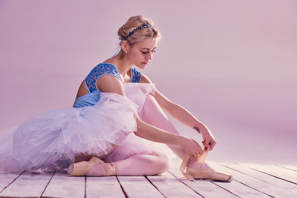 Professional ballerina putting on her ballet shoes. - Фото, изображение