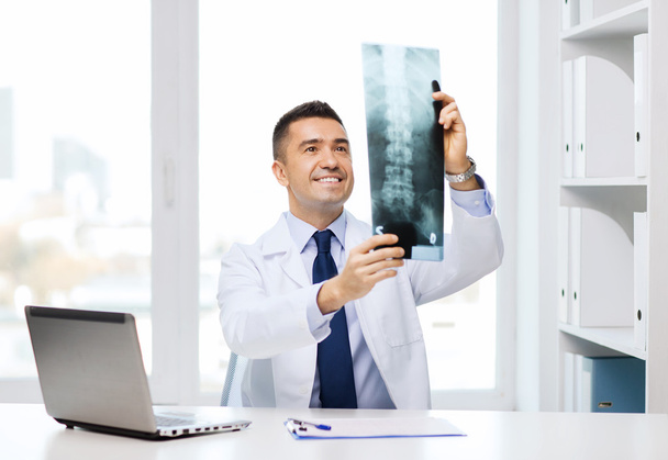 smiling male doctor in white coat looking at x-ray - Φωτογραφία, εικόνα