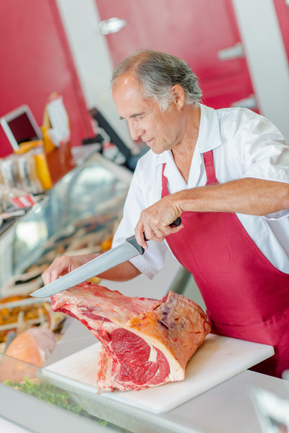 Butcher slicing a big cut of beef - Foto, Imagem