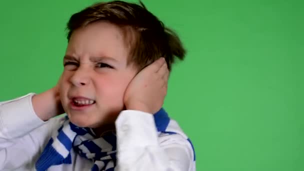 Jonge knappe kind jongen heeft betrekking op zijn oren (lawaai) - groene scherm - closeup - studio - Video