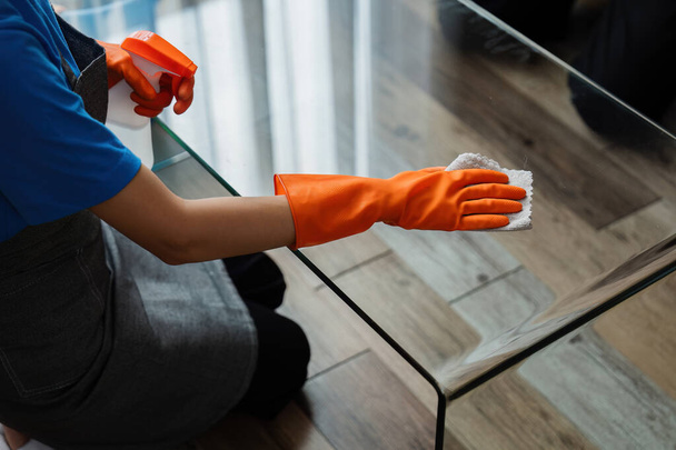 Pokojówka wycieranie tabeli w salonie Dom sprzątanie koncepcja usługi. - Zdjęcie, obraz