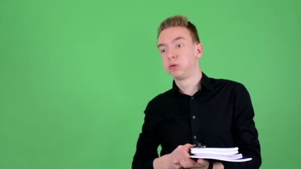 Joven hombre guapo sostiene libros de texto cansado - pantalla verde - estudio
 - Metraje, vídeo