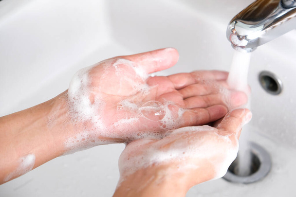 Hand der Schönheit Frau waschen Sie Ihre Hände am Waschbecken mit Schaum, reinigen Sie die Haut und lassen Sie Wasser durch die Hände fließen. Gesundheits- und Schönheitskonzepte - Foto, Bild