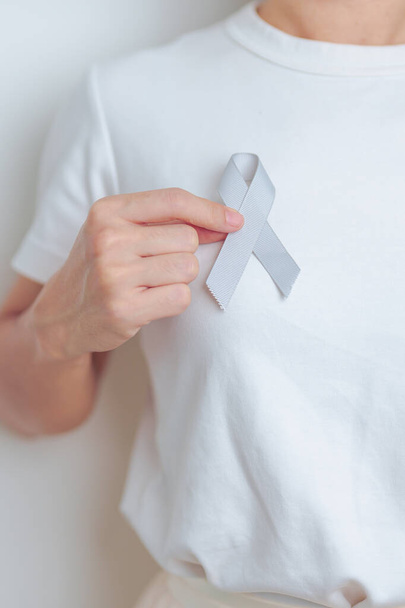 Cerveau Cancer Sensibilisation Mai mois, femme avec ruban de couleur grise pour soutenir les gens de la vie. Concept de journée mondiale de la santé et du cancer - Photo, image