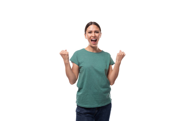 vrij vriendelijke jonge Kaukasische brunette vrouw in groen t-shirt vreugde en geschreeuw. - Foto, afbeelding
