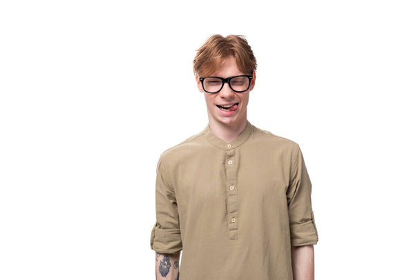 close-up portrait of a stylish european guy with red hair dressed in a fashionable brown shirt and trousers on a white background. people lifestyle concept. - Photo, Image