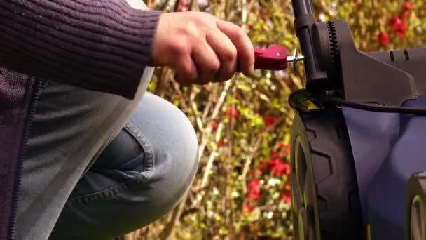 Hand fixing lawnmower in garden medium zoom shot slow motion selective focus  - Footage, Video