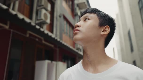Sweaty Teenager Looks Around the City After Training. Tired Handsome Young Athlete Stands and Looking Around. Sport and People Concept - Footage, Video