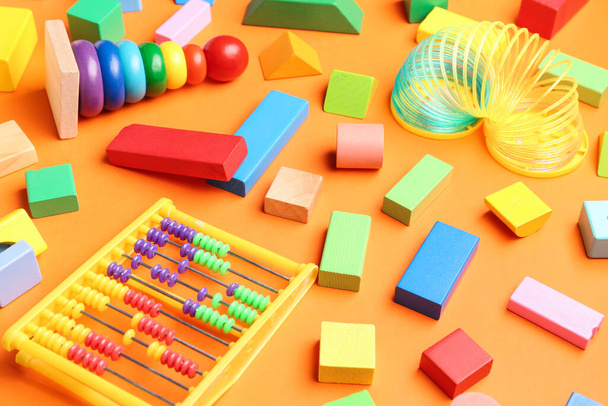 Diversi giocattoli colorati su sfondo arancione. Festa dei bambini celebrazione - Foto, immagini