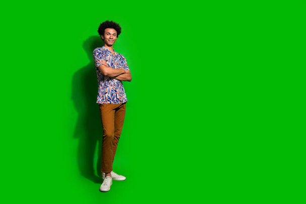 Full length body photo of young macho student funny trendy man smiling and confident crossed hands isolated on green color background. - Φωτογραφία, εικόνα