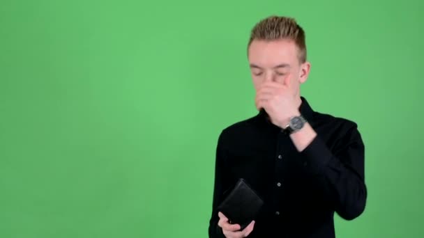 junger gutaussehender Mann sucht Brieftasche und hat Depressionen - Green Screen - Studio - Filmmaterial, Video