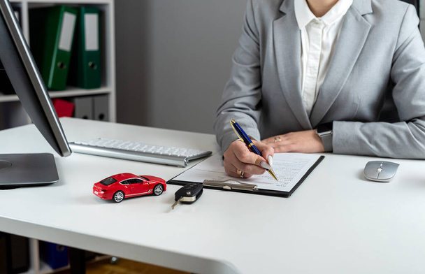 Glückliche Frau unterschreibt einen Vertrag Kreditvertrag, kauft ein neues Auto oder mietet vechicle im Büro. Kfz-Finanzierung und Versicherungskonzept - Foto, Bild