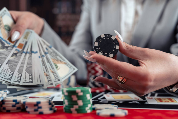 成功した女性プレーヤーは,カジノでポーカーゲームに勝った後,ドル紙幣を数えます. ギャンブルコンセプト - 写真・画像
