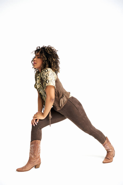 stijlvol Afrikaans amerikaans vrouw met dierlijke print op outfit poseren in beweging en kijken weg - Foto, afbeelding