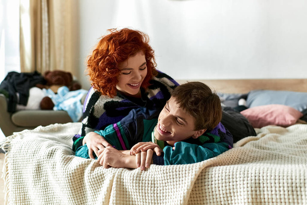 красивый стильный мужчина с наушниками отлично проводит время со своей красивой девушкой в постели дома - Фото, изображение