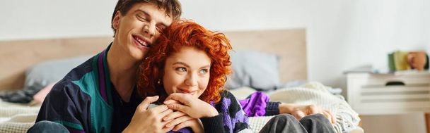 stylish jolly girlfriend and boyfriend in cozy outfits hugging each other while at home, banner - Photo, Image