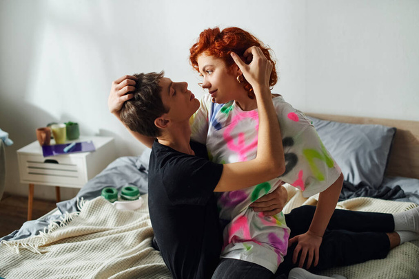 quente atraente namorado e namorada no vibrante homewear abraçando sedutoramente na cama em casa - Foto, Imagem