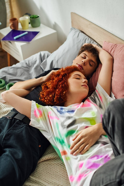 ελκυστικό ερωτευμένο νεαρό ζευγάρι σε ζωντανή homewear χαλαρώνοντας μαζί στο κρεβάτι τους, ενώ στο σπίτι - Φωτογραφία, εικόνα