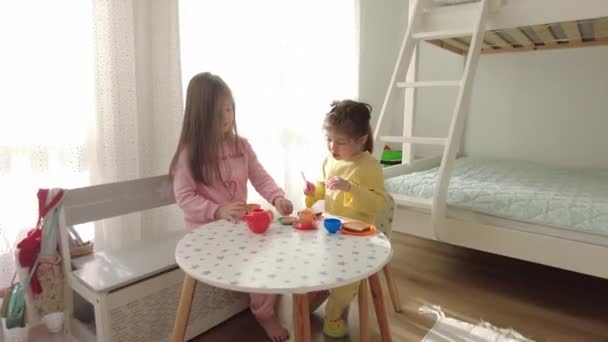 Lindas niñas jugando con juguete de plástico de cocina en el interior de casa. - Imágenes, Vídeo