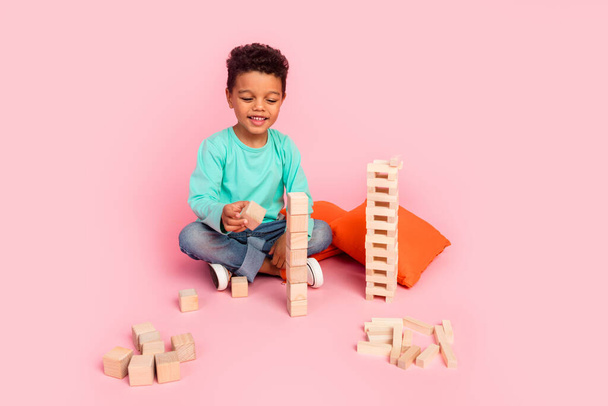 Full body photo of cute little boy play wooden blocks cubes game dressed stylish cyan clothes isolated on pink color background. - Photo, Image