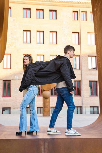 fotografia vertical de um casal compartilhando um casaco - Foto, Imagem
