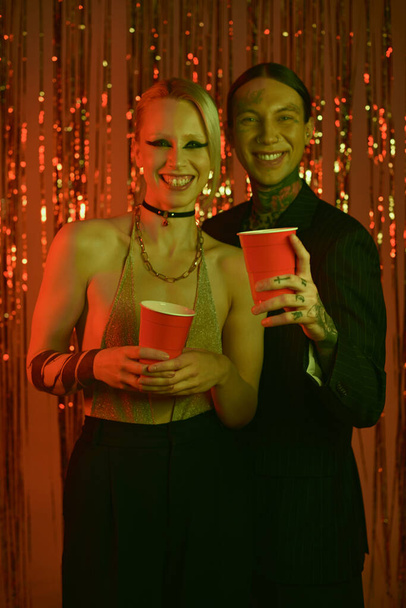 Un homme et une femme se tiennent côte à côte lors d'une rave party ou d'une boîte de nuit - Photo, image