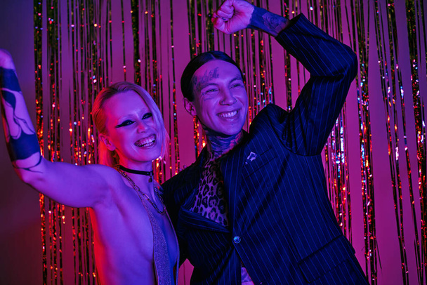 Ein Paar posiert zusammen in einem lebhaften Rave-Nachtclub - Foto, Bild