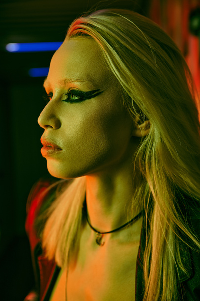 Woman with vibrant long blonde hair and bold black makeup - Foto, afbeelding